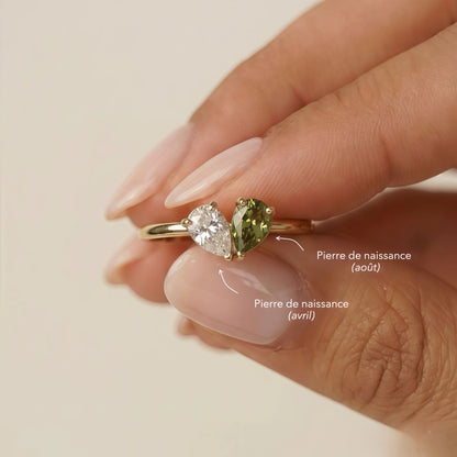 Bague Veria tenue entre les doigts, pierres de naissance août et avril