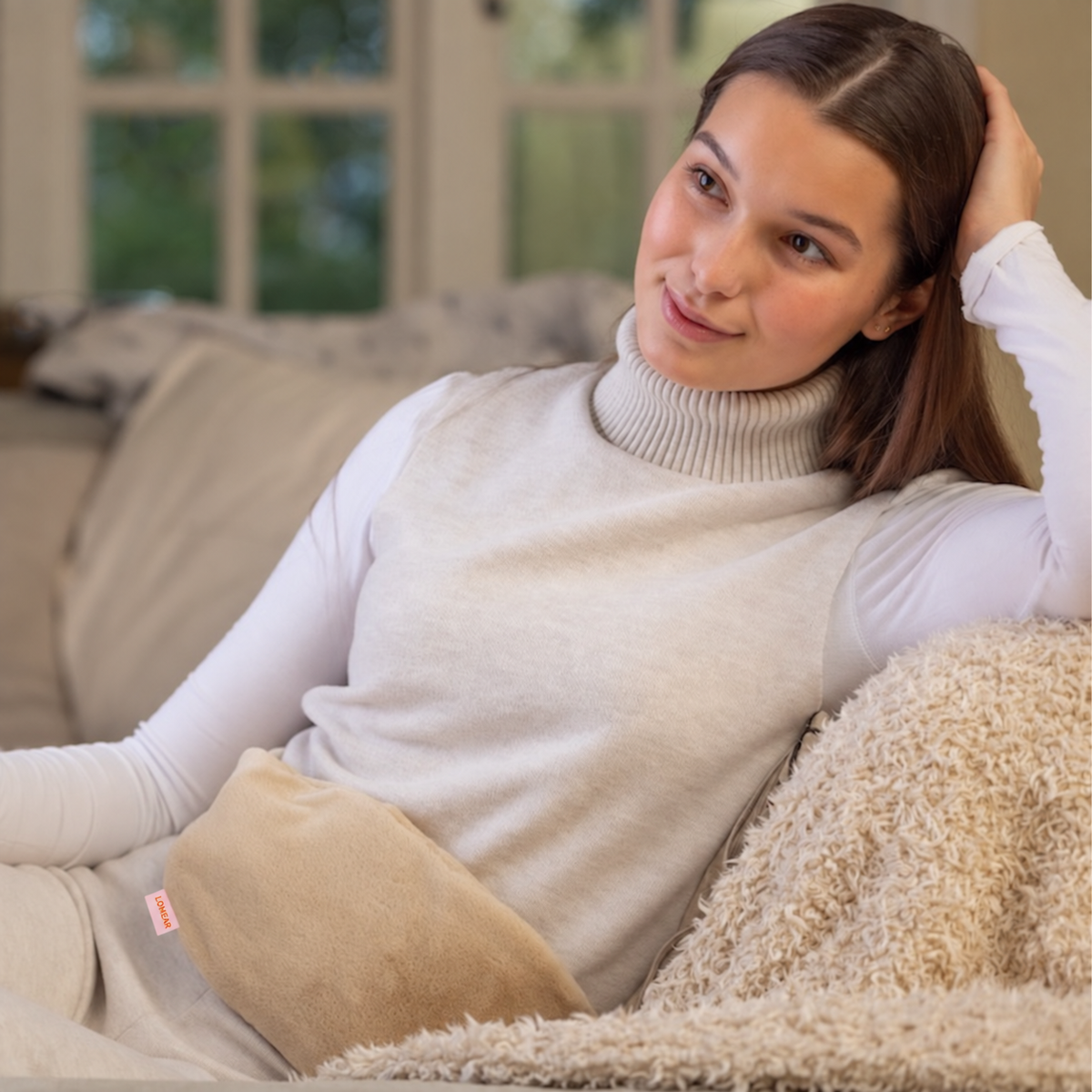 Femme portant une housse crème sur un canapé